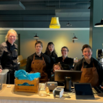 Een deel van het medewerkersteam van Tante Truus staat achter de balie in de lunchroom.
